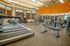 Premium fitness center with modern treadmills, ellipticals, and strength training equipment in a spacious, well-lit environment.