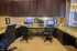 Modern home office with elegant dark wood cabinetry, dual computer workstations, and sleek granite countertops, perfect for a productive workspace.