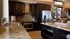 Luxurious kitchen featuring granite countertops, modern stainless steel appliances, and elegant dark wood cabinetry.