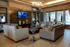 Elegant apartment lounge featuring plush seating, ambient lighting, and a mounted TV for a luxurious living experience.