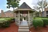 Charming outdoor gazebo surrounded by lush greenery in a serene apartment complex setting.