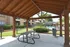 Charming apartment with a cozy wooden gazebo overlooking a lush courtyard and sparkling pool.