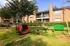 Inviting apartment exterior with charming playground in lush green setting, perfect for family living.