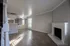 Bright and inviting living room with elegant wood flooring, cozy fireplace, and modern open kitchen design.