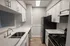 Modern galley kitchen with sleek stainless steel appliances, white cabinetry, and elegant countertops.