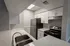 Modern kitchen with sleek stainless steel appliances, elegant white cabinetry, and sparkling countertops offering a stylish and functional cooking space.