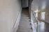 Inviting staircase leading to a bright, open-plan living area with elegant wood flooring and abundant natural light.
