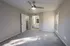 Bright and airy bedroom featuring plush carpeting, modern ceiling fan, and an ensuite bathroom.