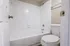 Modern bathroom with sleek white tiles, a spacious bathtub, and elegant fixtures for a refreshing oasis.