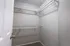 Spacious walk-in closet featuring sturdy white shelving and ample storage space, perfect for organizing your wardrobe.