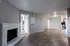 Inviting open-plan living area with elegant wood flooring and a cozy fireplace, leading into a modern kitchen and bright rooms.