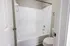 Inviting bathroom with a sleek white tiled bathtub and modern fixtures, perfect for relaxation.
