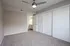 Inviting bedroom with plush carpeting, modern ceiling fan, and ample closet space, perfect for relaxation and comfort.