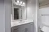 Elegant bathroom featuring a modern vanity with ample storage, sleek fixtures, and a pristine bathtub in a serene setting.