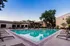 Inviting outdoor pool area surrounded by comfortable lounge chairs, ideal for relaxation in a serene residential setting.