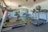 Bright and modern gym with state-of-the-art treadmills, weight machines, and spacious workout area.