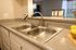 Modern kitchen with sleek double sink, elegant countertop, and ambient lighting, perfect for culinary enthusiasts.