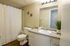 Bright and modern bathroom with elegant vanity, chic wall decor, and soft lighting.