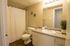 Inviting bathroom with modern fixtures, expansive mirror, and elegant decor in a cozy apartment setting.