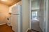 Inviting apartment view showcasing a cozy kitchen with wood flooring, leading to a bright living area with large sliding glass doors.
