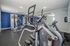 Modern fitness center with advanced cardio and strength training equipment, bright space with mirrored walls and blue accent design.