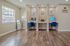 Chic home office corner featuring dual workstations with blue velvet chairs, set against elegant wood flooring and soft lighting.