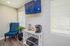 Cozy apartment corner featuring a modern coffee station with a Keurig, stylish blue chair, and natural light filtering through blinds.