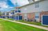 Charming apartment complex with attractive two-story design, featuring quaint balconies and inviting brick and blue accents.