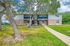 Charming two-story apartment building with picturesque greenery, featuring a vibrant blue entrance and a welcoming pathway.