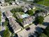 Inviting aerial view of a modern apartment complex featuring a sparkling swimming pool, ample parking, and lush green spaces.