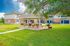 Charming outdoor pavilion with picnic tables and grills set in lush green lawn, ideal for gatherings in a welcoming apartment community.