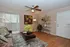 Chic living room with modern decor, featuring a cozy sofa, vibrant artwork, and elegant plants, offering a warm and inviting atmosphere.