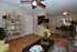 Inviting living space with modern decor, featuring vibrant green plant accents, elegant shelving, and a sleek open kitchen with a cozy dining area.
