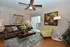 Chic living room featuring a cozy brown sofa, vibrant yellow armchair, and contemporary decor with natural light streaming through sliding glass doors.