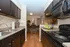 Modern kitchen with sleek countertops, dark cabinetry, and adjacent dining area offering a warm and inviting ambiance.
