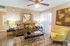 Charming living room with elegant decor, featuring a cozy brown sofa, vibrant floral centerpiece, and stylish artwork on warm-toned walls.