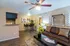 Inviting living space featuring modern decor, cozy sofa, sleek coffee table with magazines, and elegant dining area in the background.