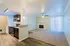 Modern open-concept apartment with elegant kitchen, cozy living room, and inviting fireplace, enhanced by natural light from large windows.