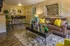 Chic living room with modern decor, featuring a plush sofa adorned with vibrant yellow pillows, stylish wall art, and a sleek dining set, all bathed in warm ambient lighting.