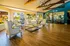 Elegant lounge area with plush armchairs, stylish chandeliers, and views of a vibrant garden through large windows.