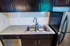 Contemporary kitchen with sleek granite countertops, dark wood cabinets, and stainless steel appliances.
