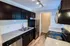 Modern kitchen with sleek granite countertops, stainless steel appliances, and stylish dark wood cabinetry.