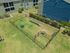 Charming outdoor pet play area with agility equipment, enclosed by a secure fence, set against modern apartment buildings.