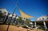 Inviting outdoor area with stylish sunshade and hammocks, featuring modern apartment building backdrop.