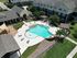 Elegant apartment complex featuring a beautifully designed swimming pool, spacious lounge areas, and lush landscaping.