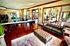 Elegant and spacious apartment interior featuring a chic leather sofa, stylish ottoman, and engaging game room with a pool table.
