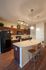Modern kitchen with sleek cabinetry, elegant lighting, and a stylish breakfast bar with chic seating.