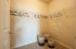 Spacious walk-in closet with elegant hanging racks and stylish woven baskets on plush carpet.