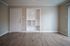 Charming apartment entry with elegant hardwood flooring and built-in shelving, offering a modern and inviting atmosphere.