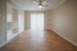 Bright and airy room with modern ceiling fan, sleek wood flooring, built-in shelving, and large sliding doors leading to natural light.
